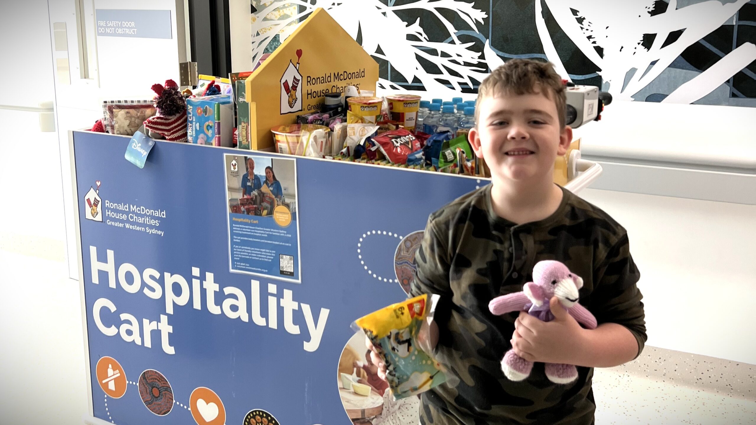 Child receiving complimentary items from the RMHC GWS Hospitality Cart at Campbelltown Hospital